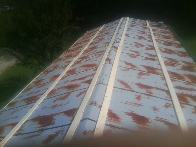Rusted metal roof panels with new wood purlins before replacement — Storm Damage Roof Repair in Thornton by Roofing Brothers