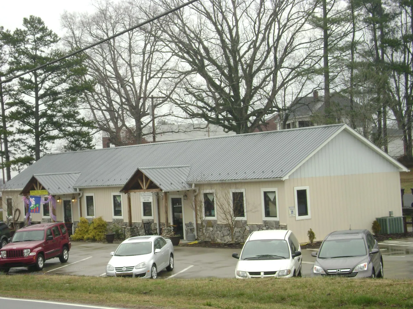 Gray metal roof with timber entry brackets on a small commercial building in Thornton
